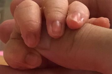 赤ちゃんの手を、そっと包む大人の手