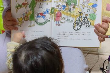 絵本を広げて読んでいる子どもたち